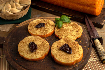 artisan cheeses with dried fruits glass of wine, homemade country bread, bunch of grapes, on wooden board with knife