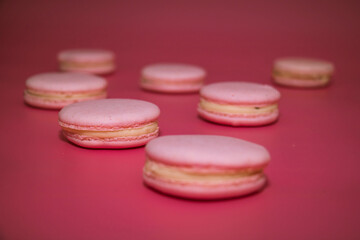 Pink macaroons lie on a pink background