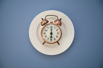 clock on the white plate on a blue background.
