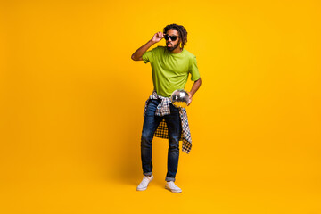 Fototapeta na wymiar Full size photo of young man hold glitter disco ball enjoy party wear checkered shirt isolated over yellow color background