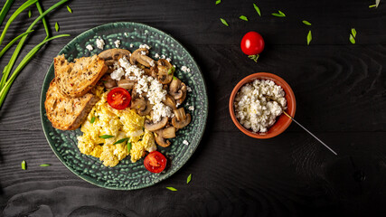 Healthy scrambled eggs with mushrooms, cottage cheese and tomatoes for breakfast. Long banner format. space for text. top view