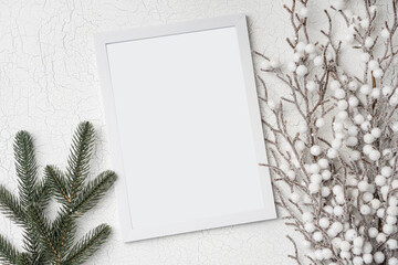 Christmas winter flatlay with empty wooden frame, fir tree branch and frozen bush. Top view background with copy space.