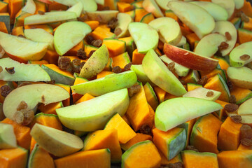 The mix of choped pumpkin, sliced apples, and raisins ready to go to the oven. Concept of healthy lifestyle, vegan diet