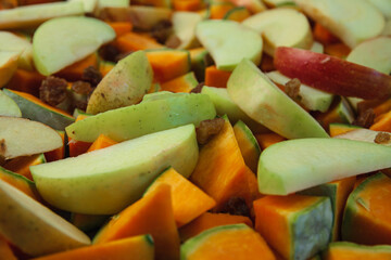 The mix of choped pumpkin, sliced apples, and raisins ready to go to the oven. Concept of healthy lifestyle, vegan diet