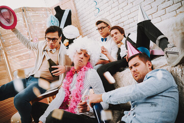 Fototapeta premium Drunk men sit near the couch and feel tired.