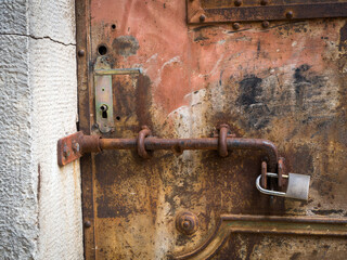 Rusty padlock on an old metal door