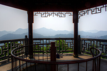 View from the top of a tower in China with surrounding mountains and bamboo forest