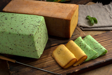artisan cheeses with dried fruits glass of wine, homemade country bread, bunch of grapes, on wooden board with knife