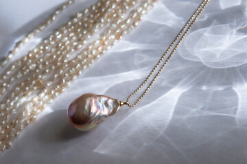 Natural baroque pearl pendant on a chain. Soft focus