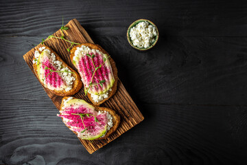 Healthy breakfast toasts from sliced watermelon radish with watermelon radish, chinese daikon, cottage cheese and microgreen. banner, catering menu recipe place for text, top view