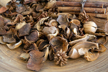 Top view of dried wood pieces in round wooden plate..