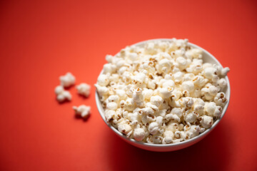 bowl of popcorn on a red background. photo with blur effect