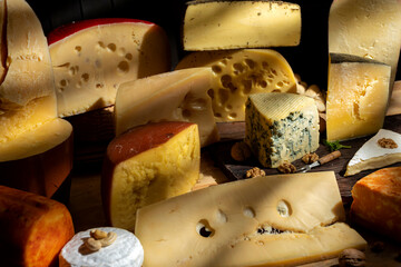 
variety of cheeses together with nuts illuminated with light from a window, with wood still life photo