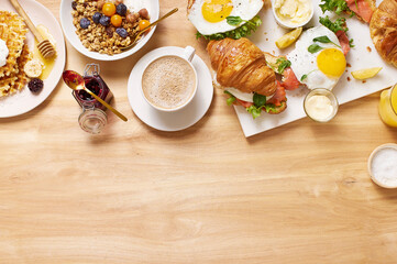 Healthy sunday breakfast with croissants, waffles, granola and sandwiches