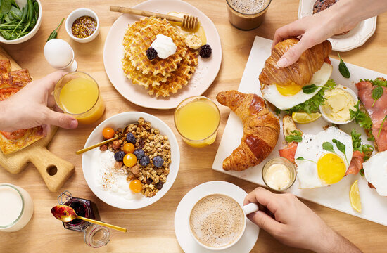 Healthy sunday breakfast with croissants, waffles, granola and sandwiches
