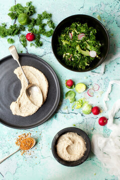 Massaged Kale salad in a bowl with hummus