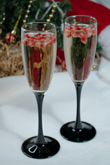 Two glasses of champagne with pomegranate seeds. Christmas background. 