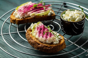 toasts from sliced watermelon radish with chinese daikon, cottage cheese and microgreen. Food recipe background. Close up