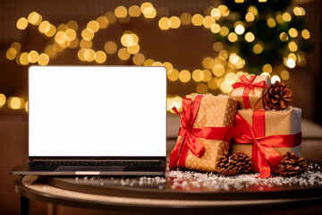Computer laptop with blank white screen on the table with gifts and pine cones. festive background