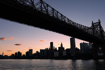 The Queensboro Bridge with a Silhouette of the Manhattan Skyline during Sunset along the East River in New York City