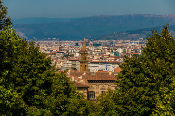 Splendid view from Boboli Gardens between two trees overlooking Florence. In the centre is the Palazzo Pitti and the bell tower of Basilica di Santo Spirito and in the background the Tuscan landscape.