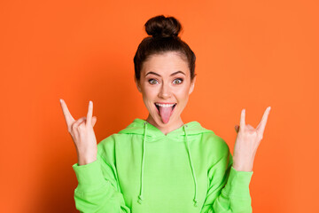 Photo of lovely tricky young lady dressed green sweatshirt showing heavy rock sign isolated bright...