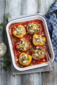 Peppers stuffed with rice, feta, mushrooms, dill and parsley in tomato sauce with feta cheese