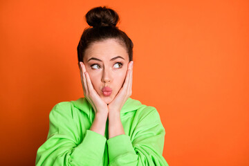 Photo portrait of pouting girl touching face cheeks with two hands isolated on vivid orange colored background