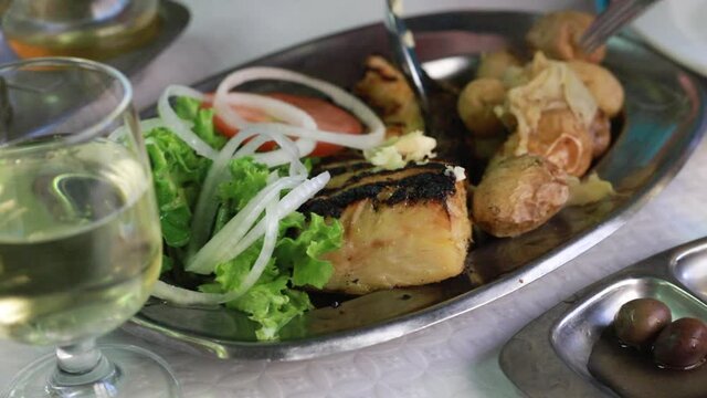 people eating typical portuguese dish cod fish with potato in restautrante
