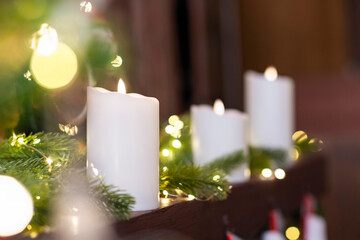 Selective focus of burning candle in Christmas decoration with light bokeh. Close up