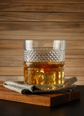Glass of whiskey on a wooden background