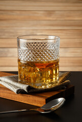 Glass of whiskey on a wooden background