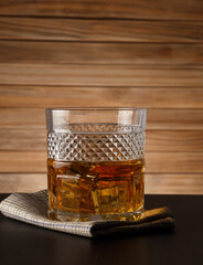Glass of whiskey on a wooden background
