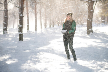 Woman stands in forest during snowstorm. Sudden blizzard concept.