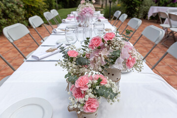 Wedding table decorated with bouquet of pink flowers and wine glasses.