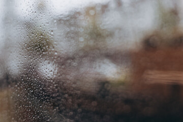 raindrops on a panoramic window, view from the middle of a coffee shop on a city street during a downpour. selective focus, copy space