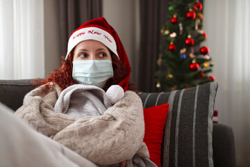 Christmas and coronavirus time, lonely woman with face mask in quarantine.
