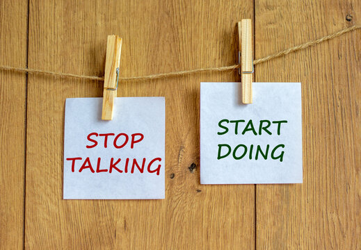 Time to start doing. Wooden clothespins with white sheets of paper. Text 'stop talking start doing'. Beautiful wooden background. Business, motivation and start doing concept, copy space.