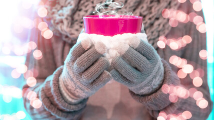 Christmas winter background - Young pretty woman with gloves and scarf stands outdoor and holds a...