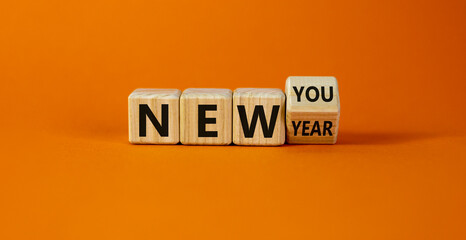 New year time. Turned a cube and changed the words 'new year' to 'new you'. Beautiful orange background. Copy space. Business and new year concept.