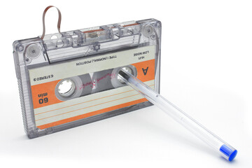rolling up old cassette tape for recording music on white background