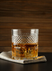 Glass of whiskey on a wooden background