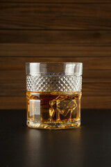 Glass of whiskey on a wooden background