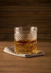 Glass of whiskey on a wooden background