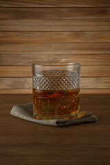 Glass of whiskey on a wooden background