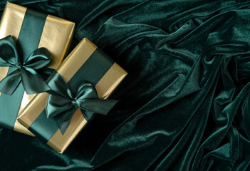 Gift boxes wrapped in gold paper with tidewater green satin ribbons. Happy New Year.