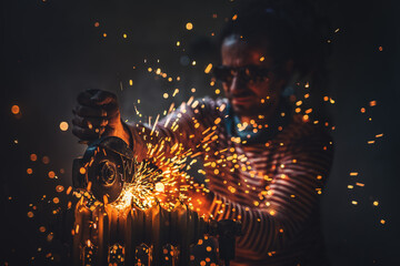 Worker cutting metal with grinder. Sparks while grinding iron.