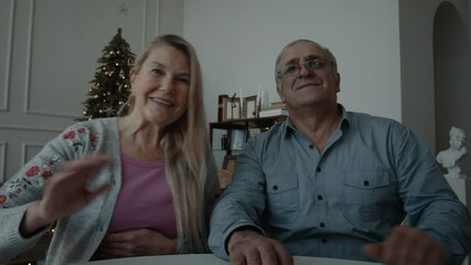 POV webcam view, Senior mature adult Caucasian couple having a video call with friends or family on Christmas eve. Holidays celebration during COVID-19 Coronavirus lockdown