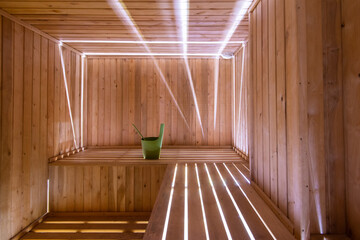 sauna interior baths with planks and a bucket light spacious