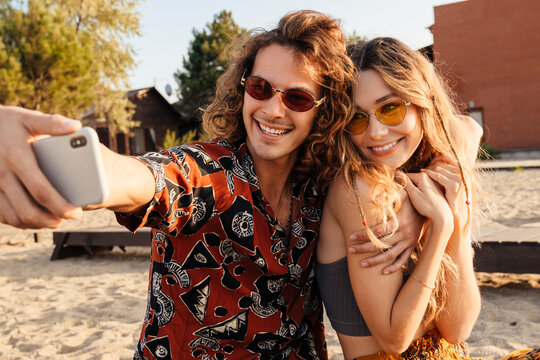 Loving couple at the beach taking a selfie by mobile phone